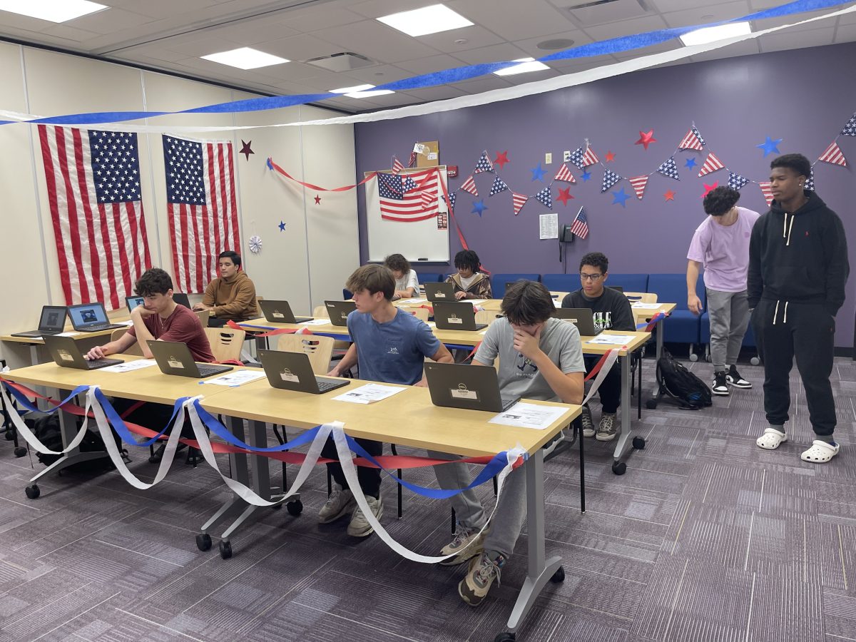 LHS students casting their votes on the computers, after receiving instructions from a mock election worker. 