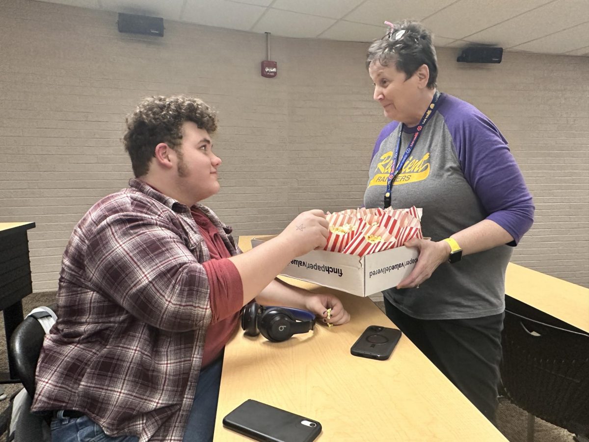 Mrs.Pesta passing out popcorn before the movie