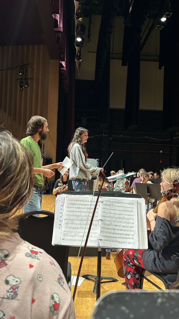 Junior Abby Peck being taught how to conduct by Orchestra Teacher Michael Dandron