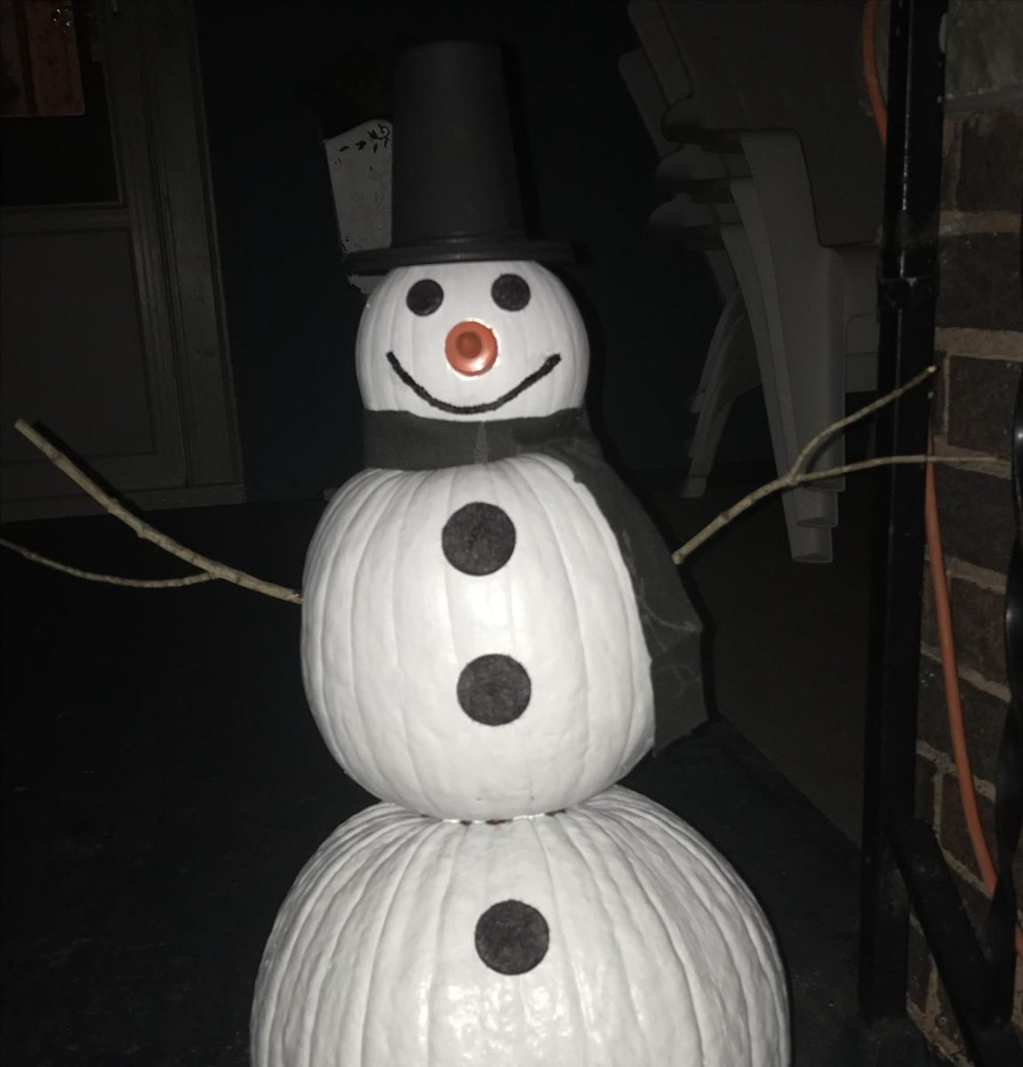 This snowman won't melt at the Kowalski household. It's made out of three recycled pumpkins, white and black paint, sticks, and an old can. 