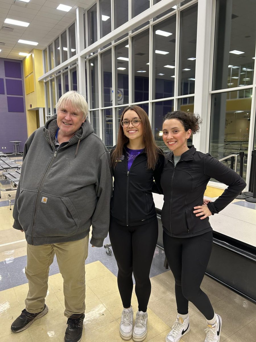 Teddie Bruening is smiling in between the two best coaches on picture day!