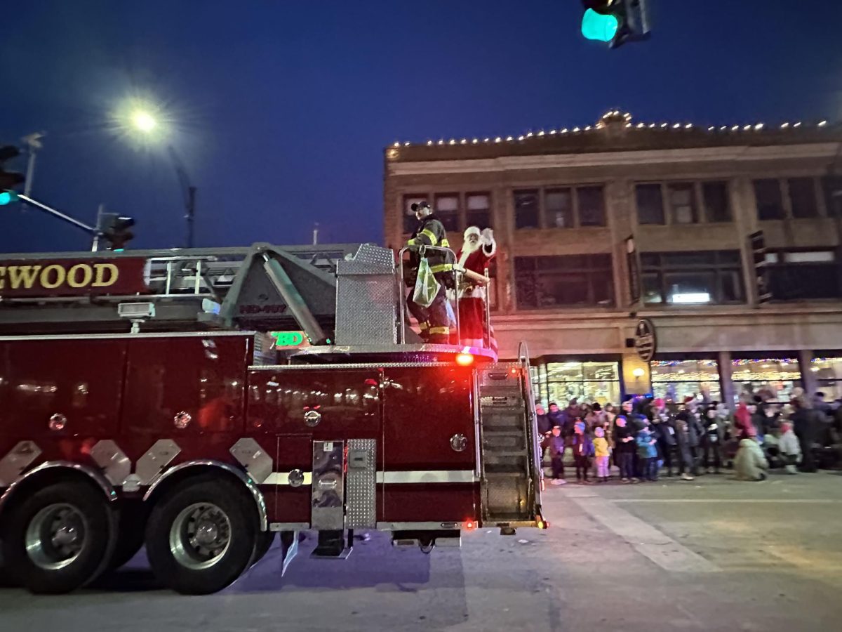 Santa Claus joyfully waves to the crowd from the top of the Lakewood firetruck in the parade. 