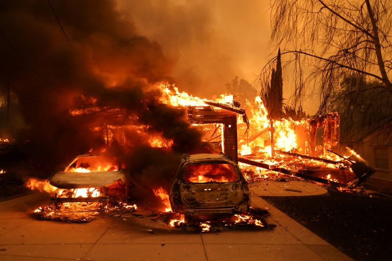 Vehicles and a house burn as powerful winds fueling devastating wildfires in the Los Angeles area force people to evacuate, at the Eaton Fire in Altadena, California, U.S. January 8, 2025. REUTERS/David Swanson