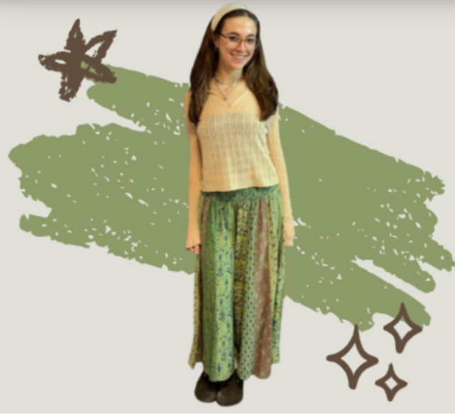 Evey's first outfit consists of a creme-colored sweater and green and brown patterned maxi skirt paired with silver necklaces, gold hoop earrings, and glasses. Photo credit: Amy Garritano, edited by Madison Twining