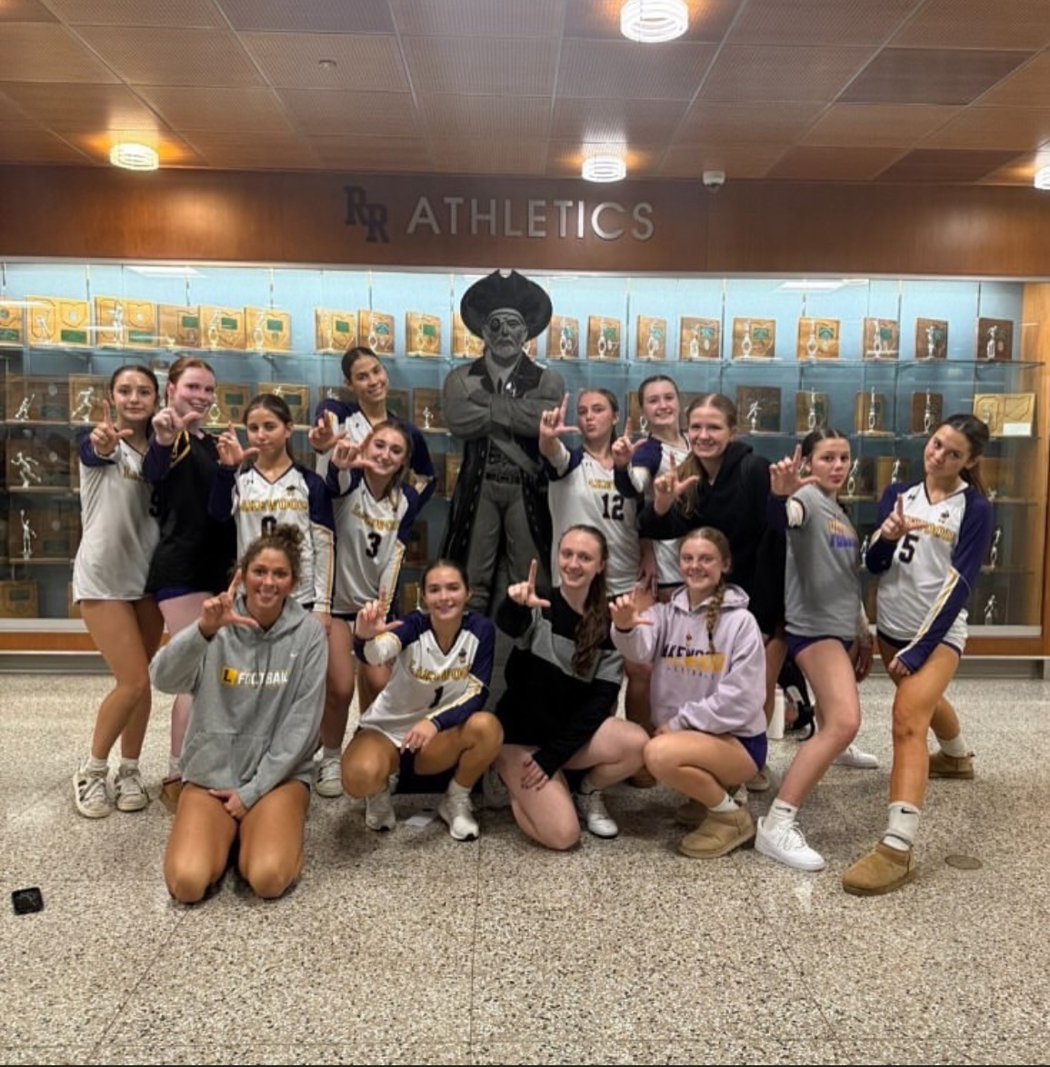 Lakewood's volleyball team celebrates their win infront of Rocky River's statue.