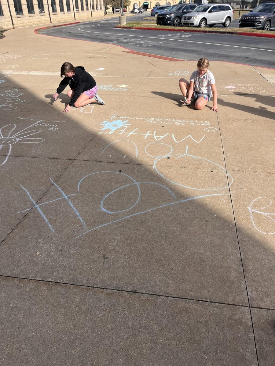 Middle schoolers are working on this week's project by drawing kind words on Harding’s sidewalks.
