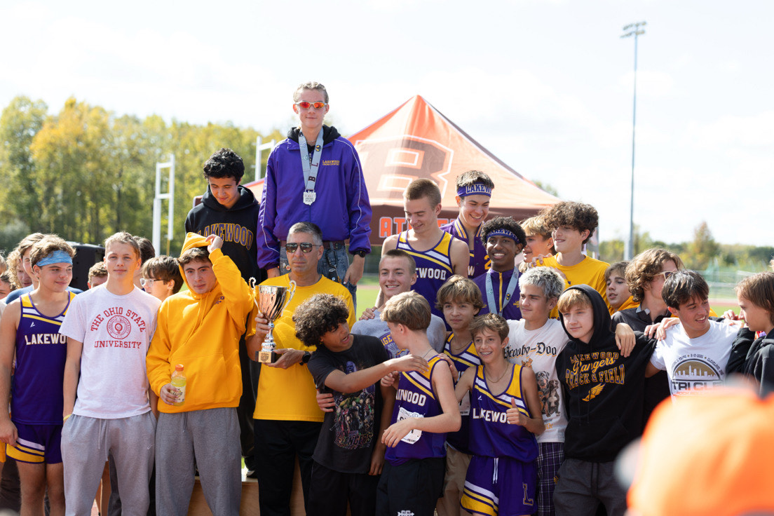 Coach leads the boys as they line up to take in their conference title win (Left to RIght: Max Presick, Connor Coleman, Ethan Moore, Jameson Walker, Porter Gilliland, Charles Moore, Marcos Severino, Miles Evans, James Babson, Will Costello, Nate Lardi, Will Schuldt, Andrew Babson, Dezzie Stevenson, Finn Haney, Landon Vincel, Zach Carnivole, Cooper Campen, Evan Siler, Caden Sandoval, Alex Mossberg)