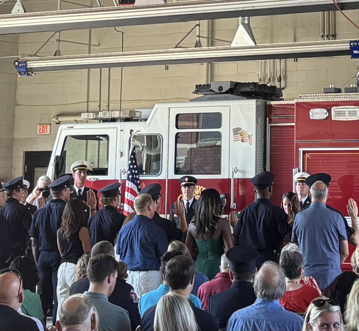 Newly recruited firefighters participate in the swearing-in ceremony, accompanied by a loved one.