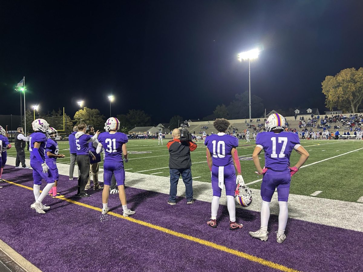 Football players on the sideline at Senior Night