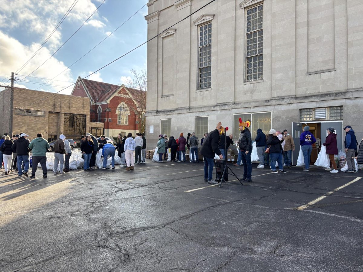 Dozens of volunteers line up around the parking lot of the Lakewood Masonic Temple to bag food before delivery.