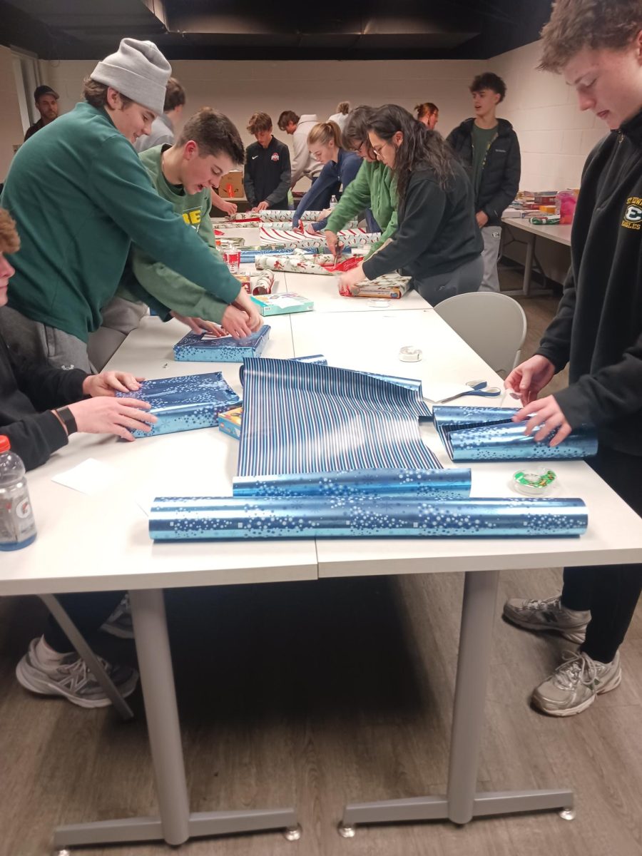 St. Edwards hockey players wrapping gifts at the Wrapping Party.