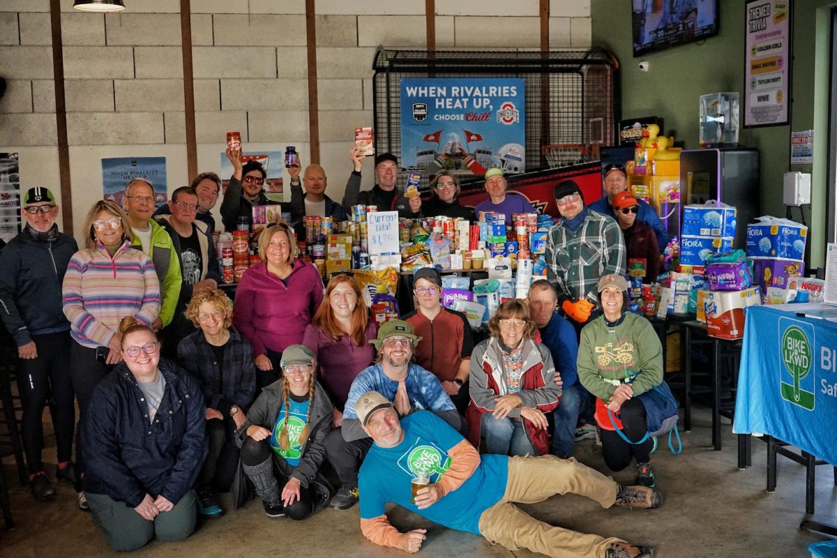 Cranksgiving participants gather around the total amount collected at the end of the event.