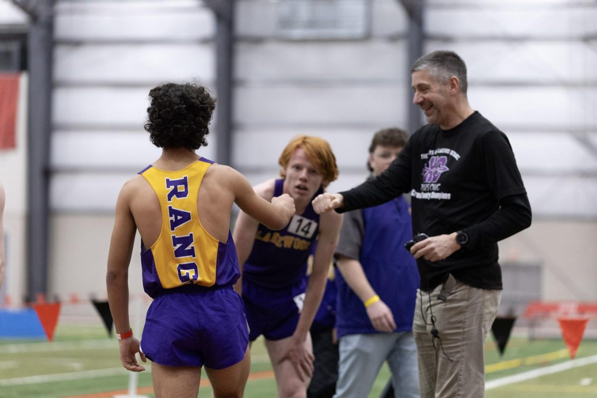 Coach Moore congratulates the runners after a good race.