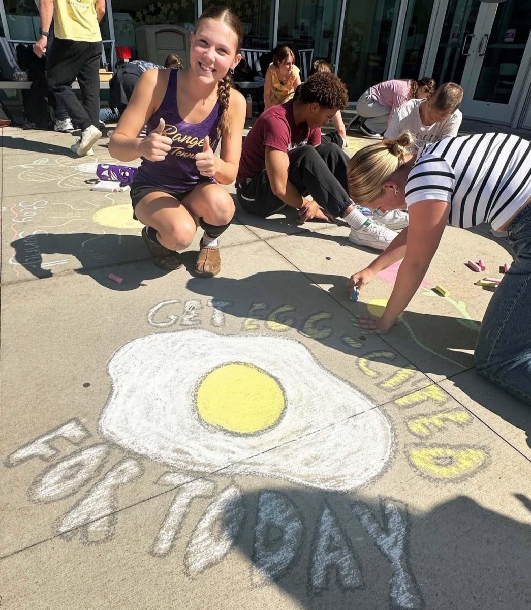 NHS members draw positive messages outside the Lakewood High School entrance.