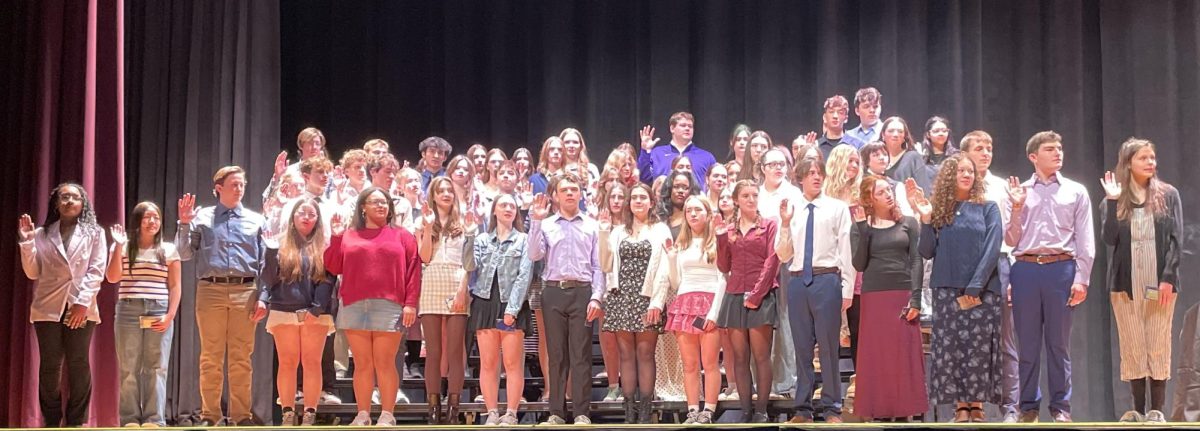 NHS inductees being sworn in on stage, officially becoming members of the organization.
