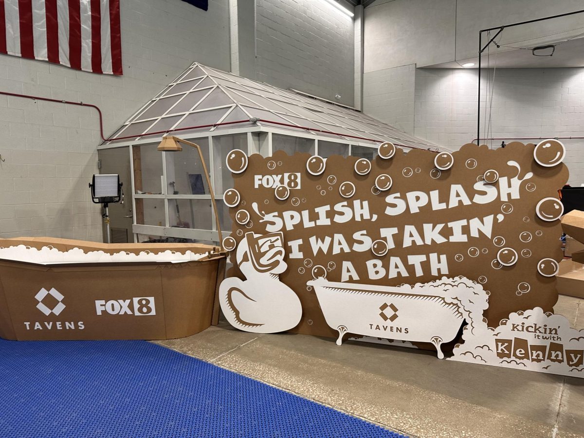 A cardboard bathtub display reading, “Splish Splash I Was Taking a Bath," sits beside a Fox 8 News sign during the morning boat regatta on March 4.