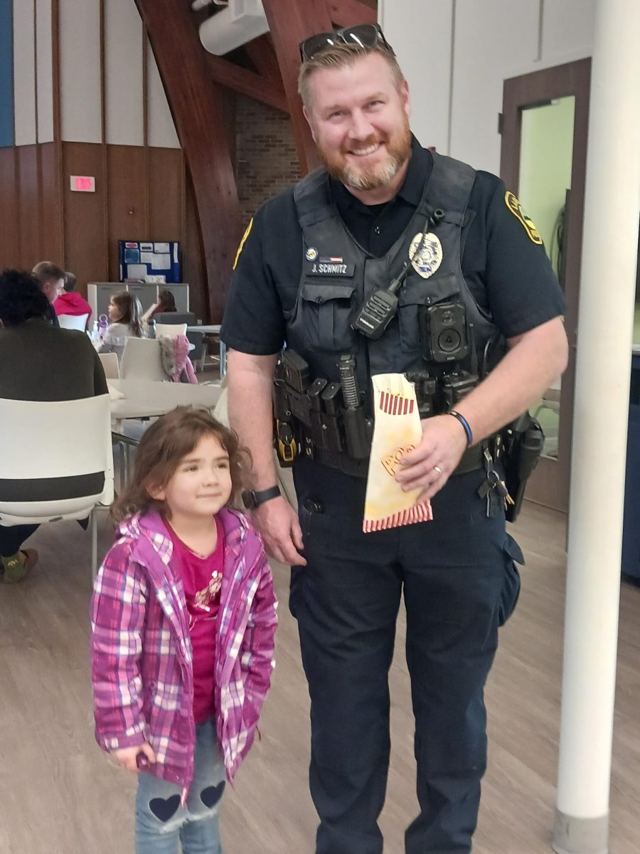 A child poses for a photo with a Lakewood police officer at Cove Community Center.