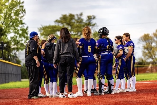The softball team huddles during a game.